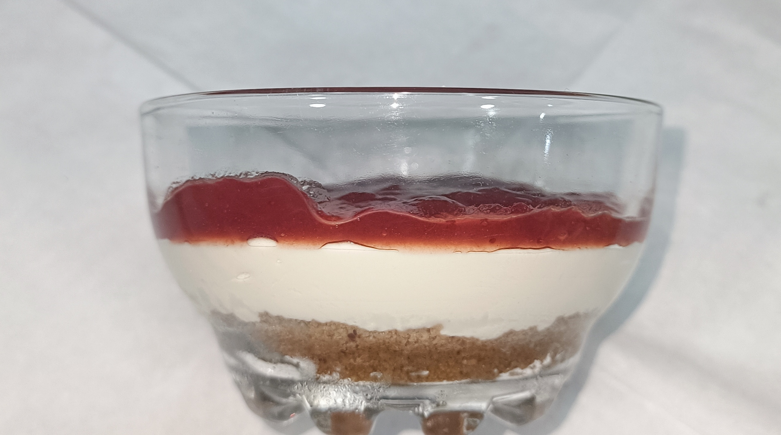 Tarta casera de queso con mermelada de fresa.