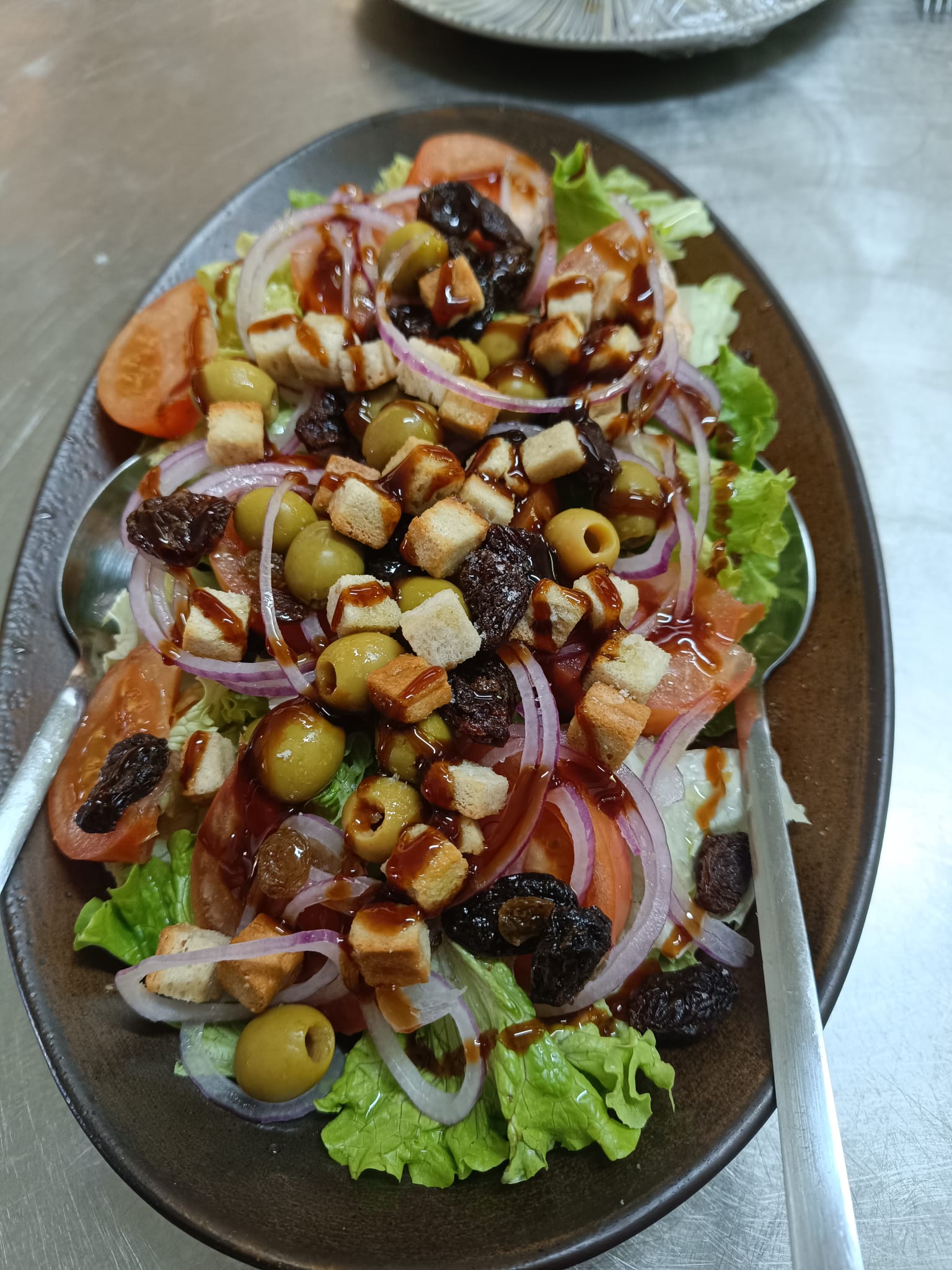 Ensalada mixta con pasas y costrones de pan fritos
