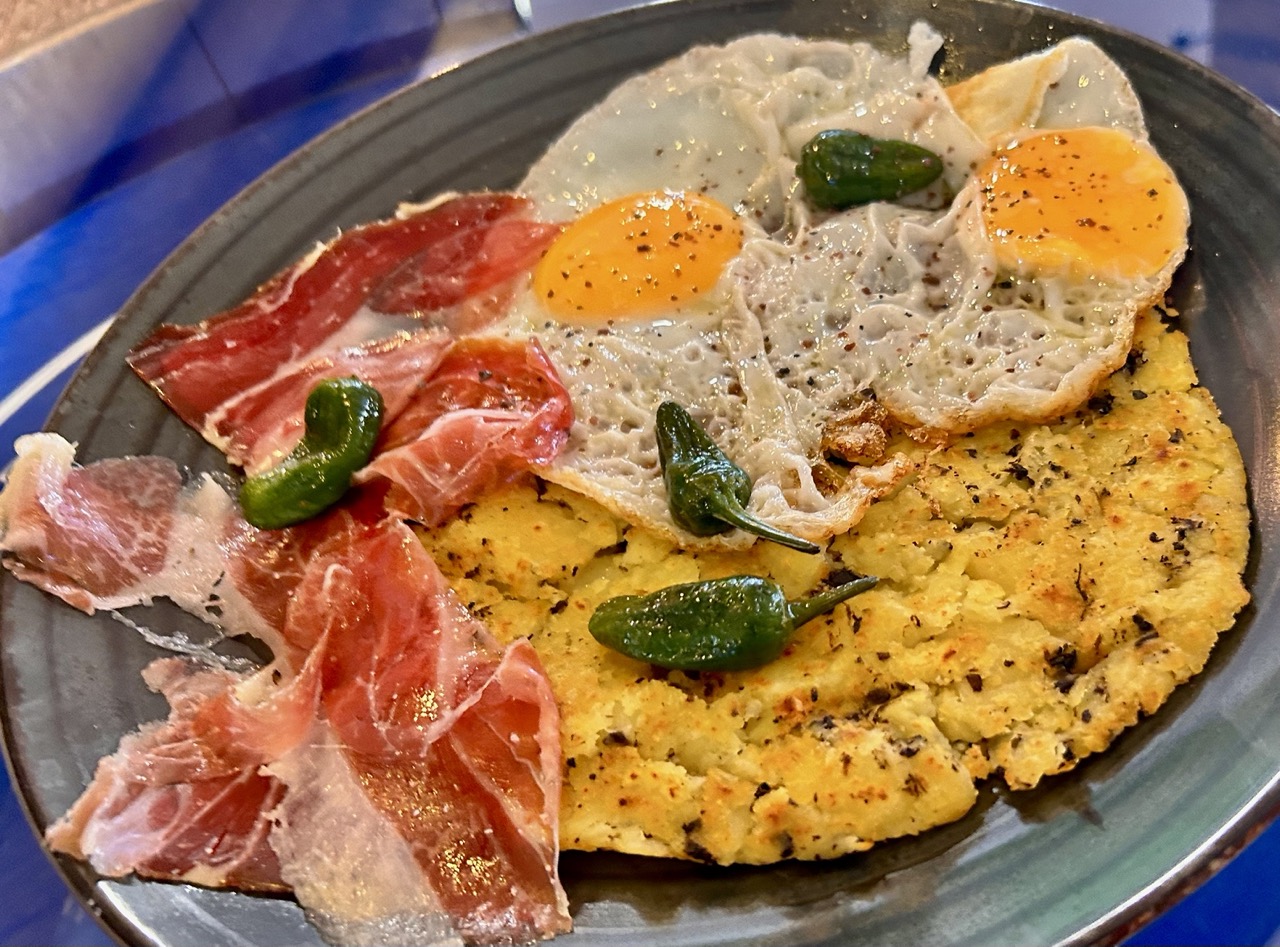 Huevos rotos con patata trufada y jamón ibérico de cebo