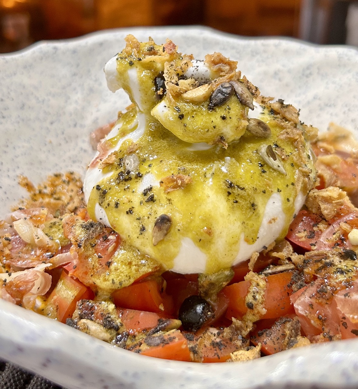 Burrata con tomate de temporada, cebolla encurtida y pestos