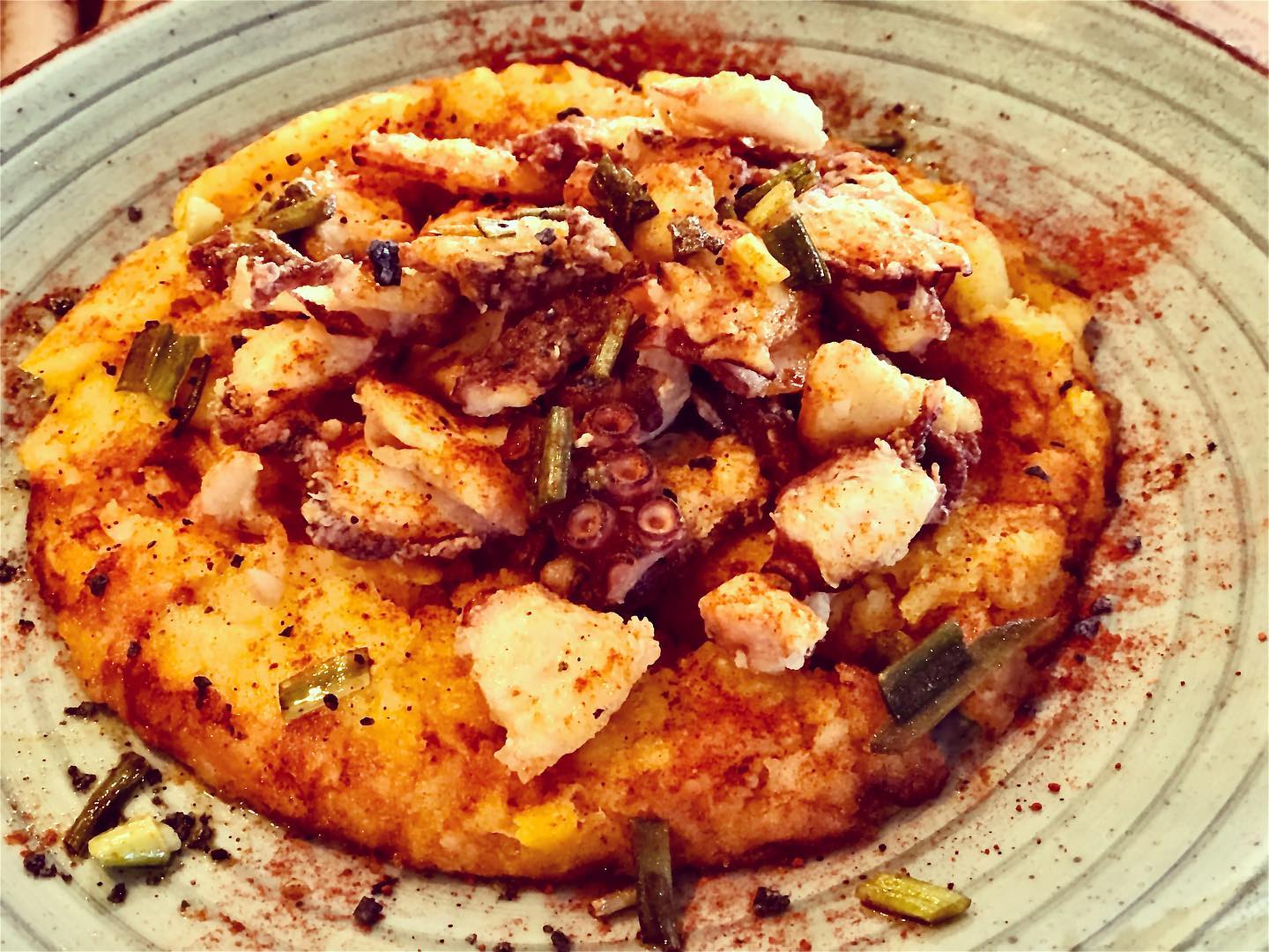 Pulpo frito con patata base y ajetes tiernos