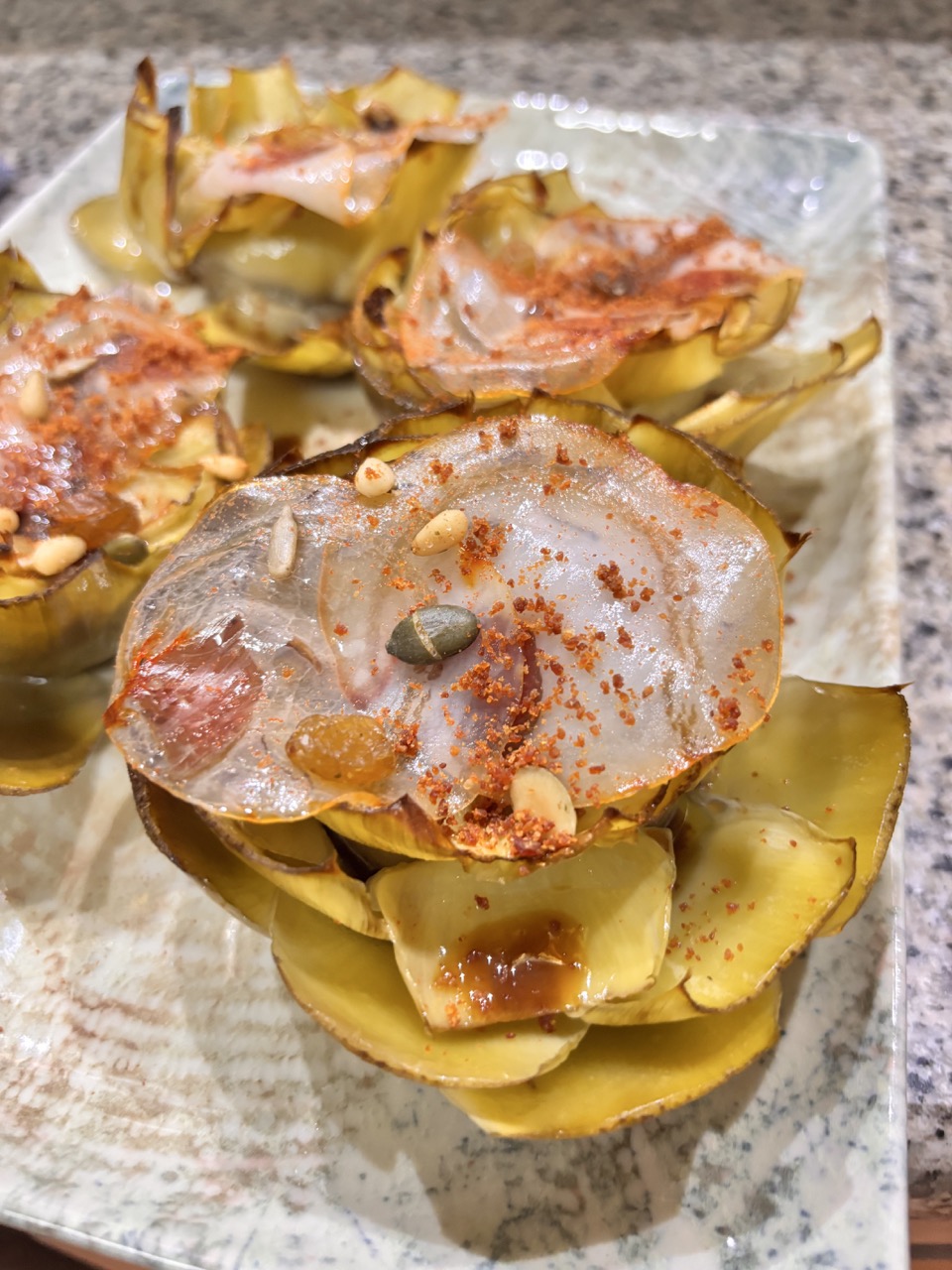 Alcachofas confitadas con yema macerada y velo de panceta ibérica de bellota