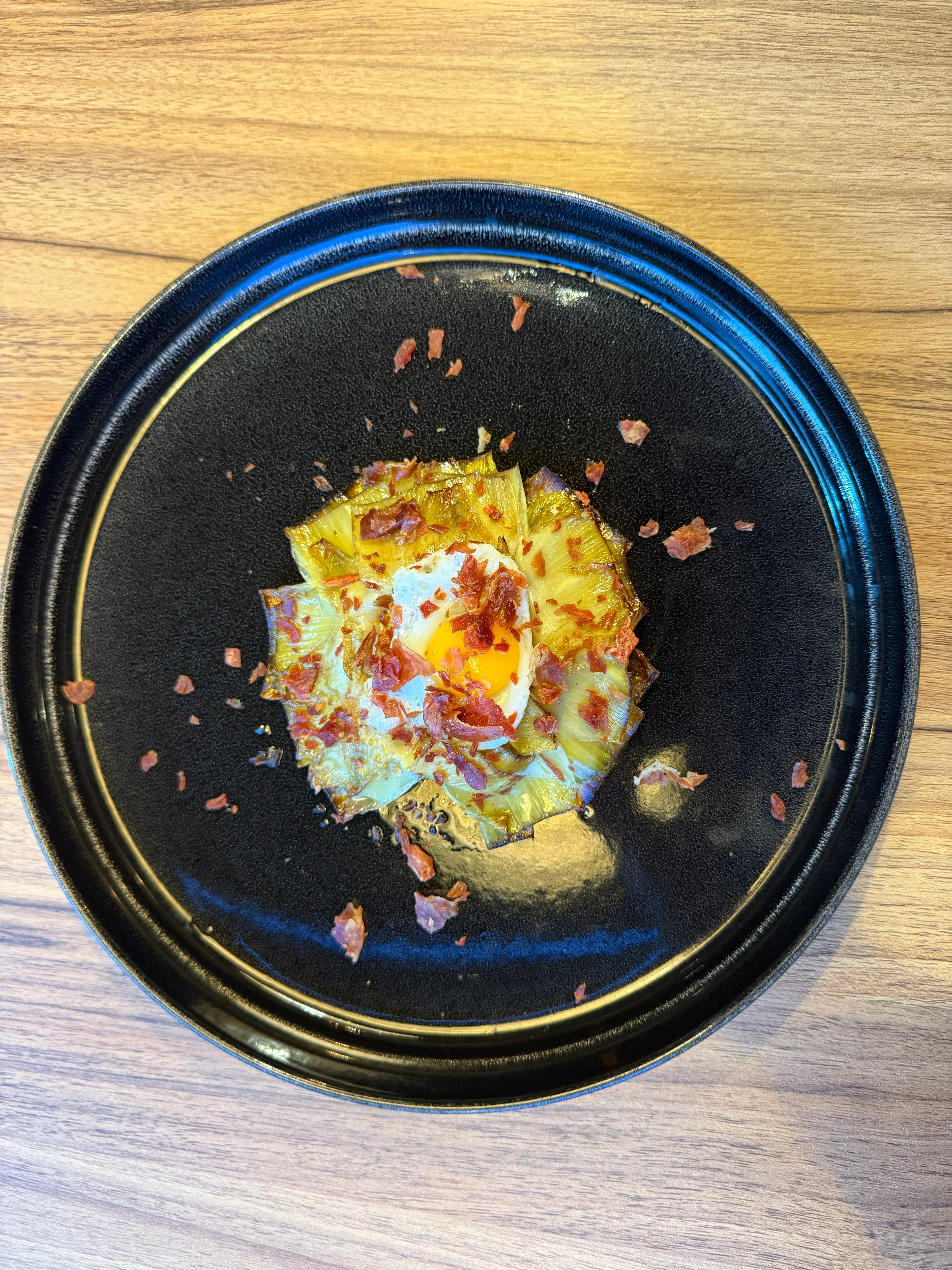 Alcachofas confitadas a la plancha con virutas de jamón y huevos de codorniz